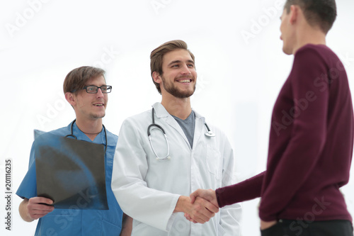 Fototapeta Naklejka Na Ścianę i Meble -  smiling doctor shaking hand of a patient