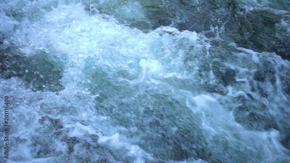 SLOW MOTION: flowing water over stones in mountain river SLOW MOTION: flowing water over stones in mountain river