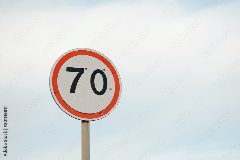 road sign speed limit 70 km on blue sky background. road sign speed limit 70 km on blue sky background.