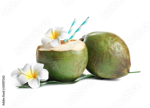 Fresh green coconuts with drinking straws and flowers on white background