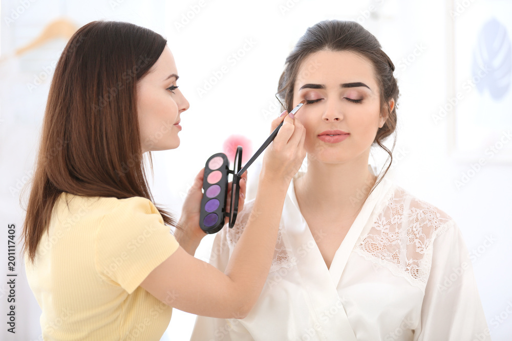 Professional makeup artist working with young woman in salon Professional makeup artist working with young woman in salon