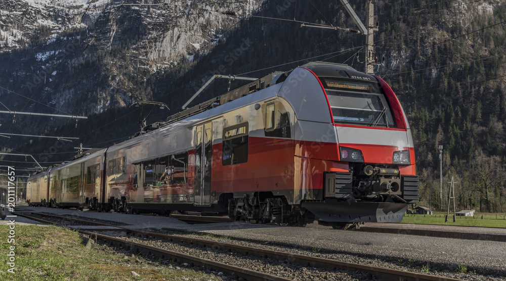 Red electric fast train in Austria Alps mountains