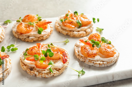 Delicious small sandwiches with shrimps on marble board