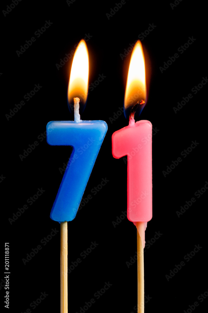 Burning candles in the form of 71 seventy one (numbers, dates) for cake isolated on black background. The concept of celebrating a birthday, anniversary, important date, holiday, table setting