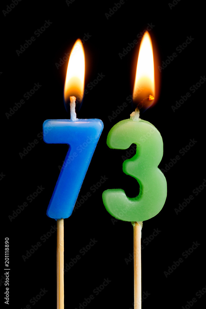 Burning candles in the form of 73 seventy three (numbers, dates) for cake isolated on black background. The concept of celebrating a birthday, anniversary, important date, holiday, table setting Burning candles in the form of 73 seventy three (numbers, dates) for cake isolated on black background. The concept of celebrating a birthday, anniversary, important date, holiday, table setting