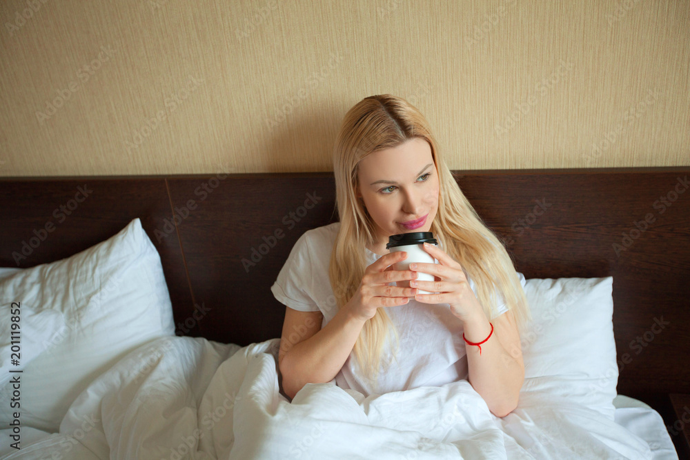 beautiful young girl in bed with a cup of coffee in the morning beautiful young girl in bed with a cup of coffee in the morning