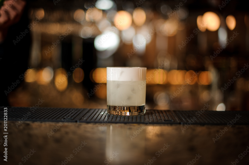 White cocktail in the glass on the bar stand White cocktail in the glass on the bar stand