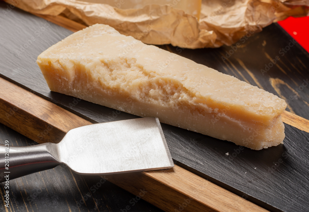 Aged Italian parmesan hard cheese Parmigiano-Reggiano with cheese knife