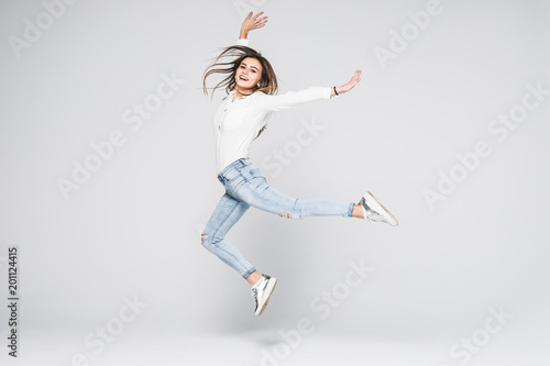 Tablou canvas Full length portrait of a cheerful woman jumping isolated on a white background