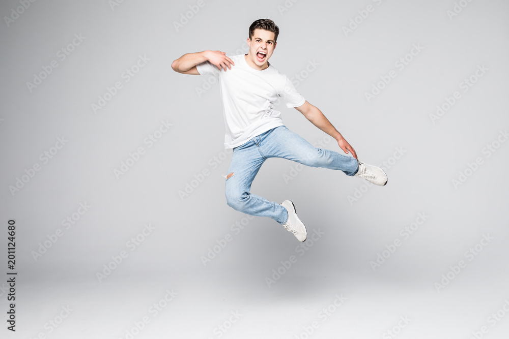 Cheerful young man jumping over white background Cheerful young man jumping over white background