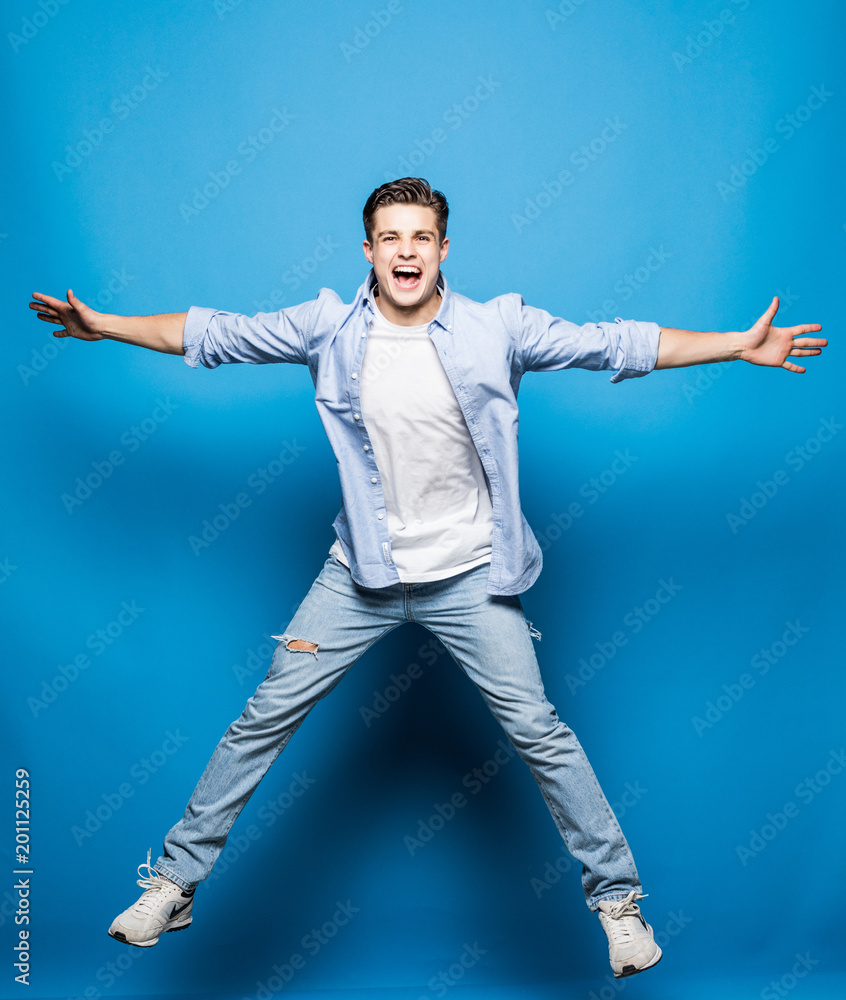 Handsome man jumping isolated on blue background