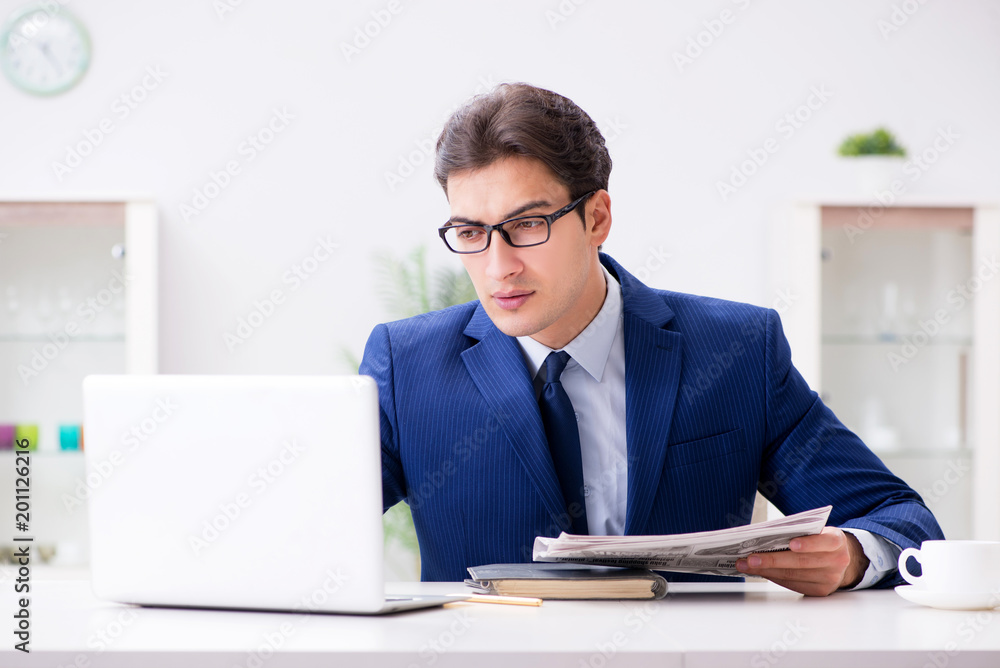 Young handsome businessman employee working in office at desk Young handsome businessman employee working in office at desk