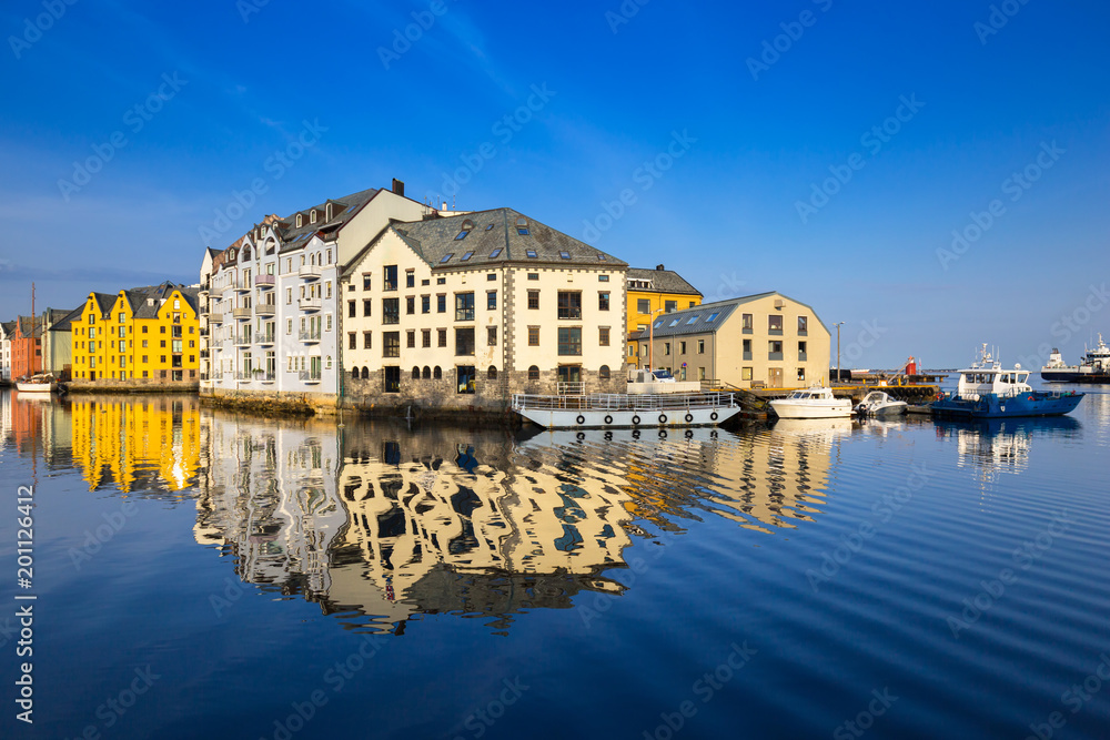 Obraz premium Architecture of Alesund town reflected in the marina canal, Norway