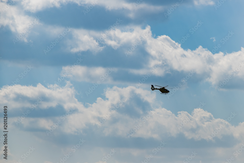 Helicopter am Himmel mit dicken Wolken, Dicke Wolken und blauer Himmel, schöne große Wolken und Hubschrauber