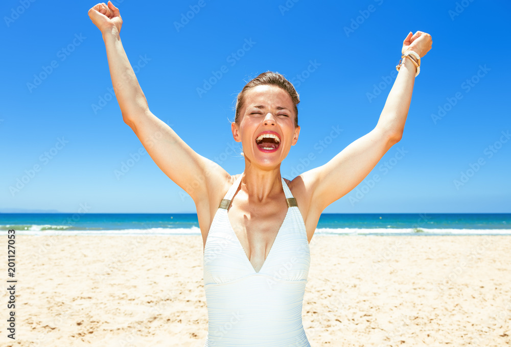 smiling young woman in beachwear on seashore rejoicing smiling young woman in beachwear on seashore rejoicing