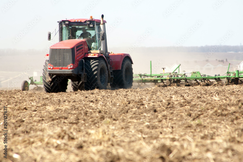 Farmer in tractor preparing land with seedbed cultivator Farmer in tractor preparing land with seedbed cultivator