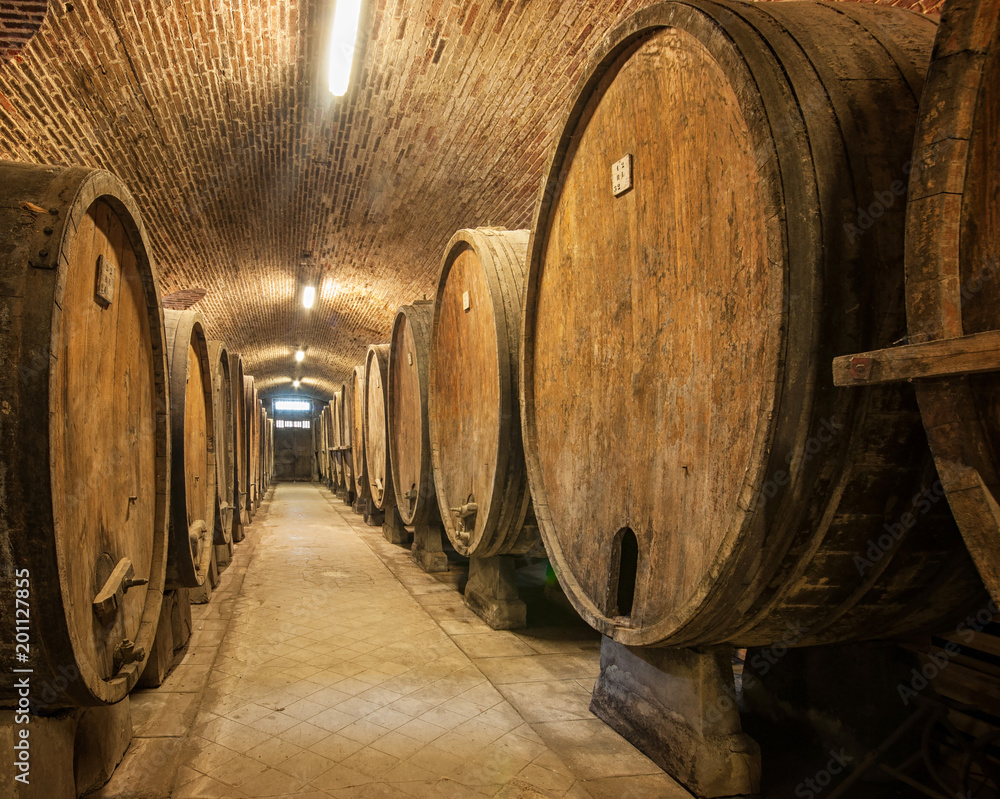 Old wooden barrels with wine in a wine vault