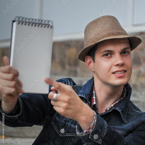 Smart young man hold notepad with mock up area for your advertising text message during preparing training project sitting with interesting literature photo