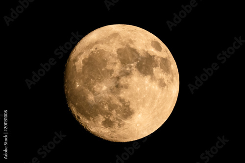 Closeup of a large shining full moon against dark background