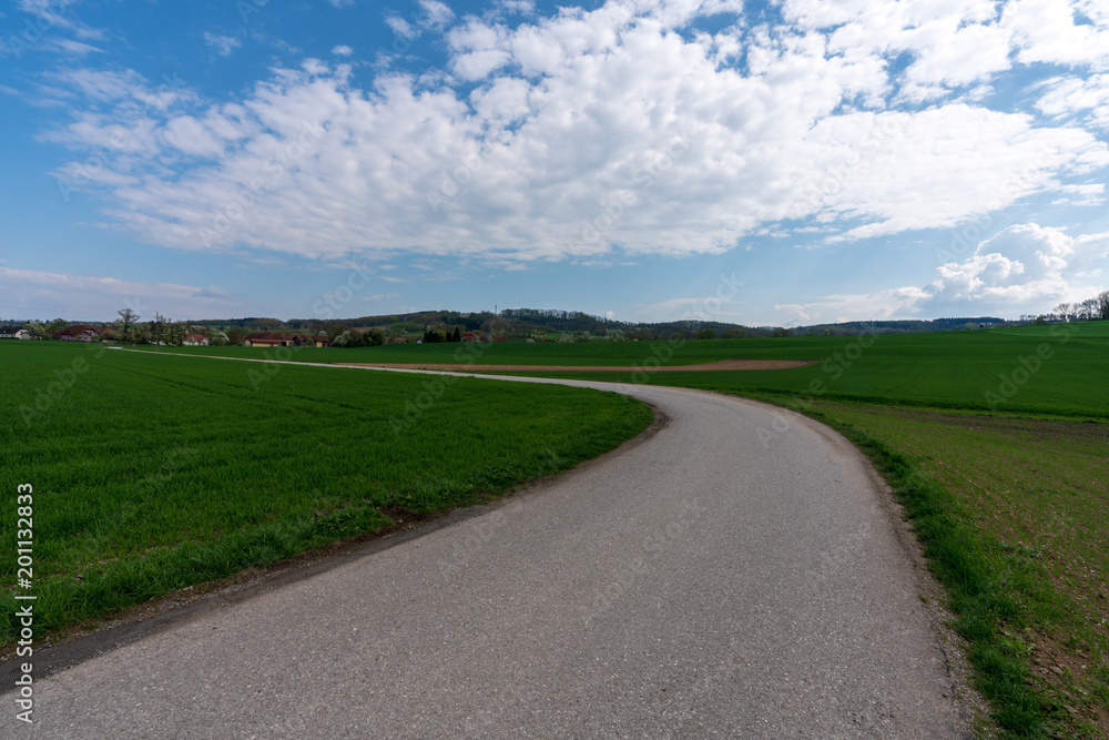 Hügelige Landschaft mit kurviger Landstraße Hügelige Landschaft mit kurviger Landstraße
