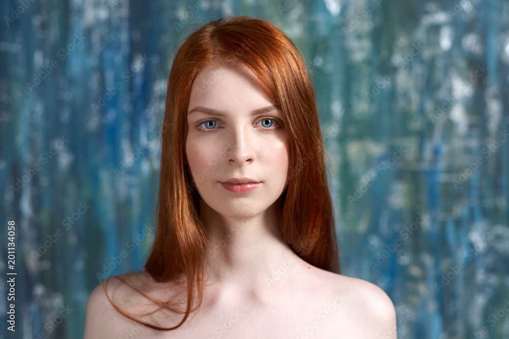 contrast Studio portrait of a young woman with long red hair and pure white skin on the face and shoulders. contrast Studio portrait of a young woman with long red hair and pure white skin on the face and shoulders.