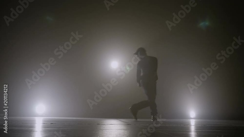 Famous singer performing hip hop dance style on the stage with smoke