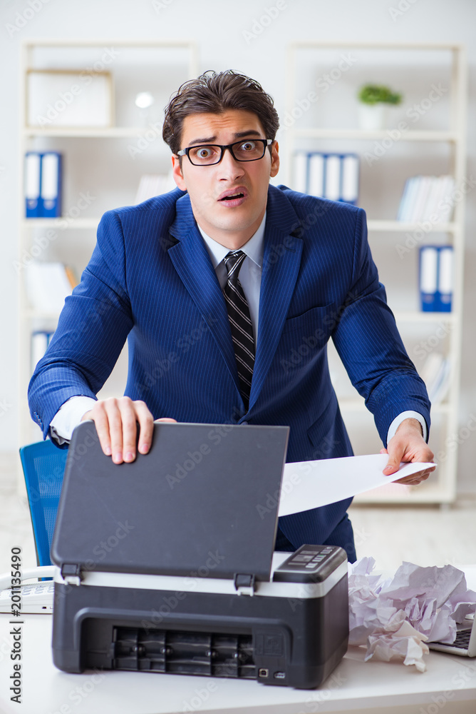 Businessman angry at copying machine jamming papers Businessman angry at copying machine jamming papers
