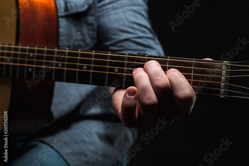 acoustic guitar in the hands of the guy on the whole frame