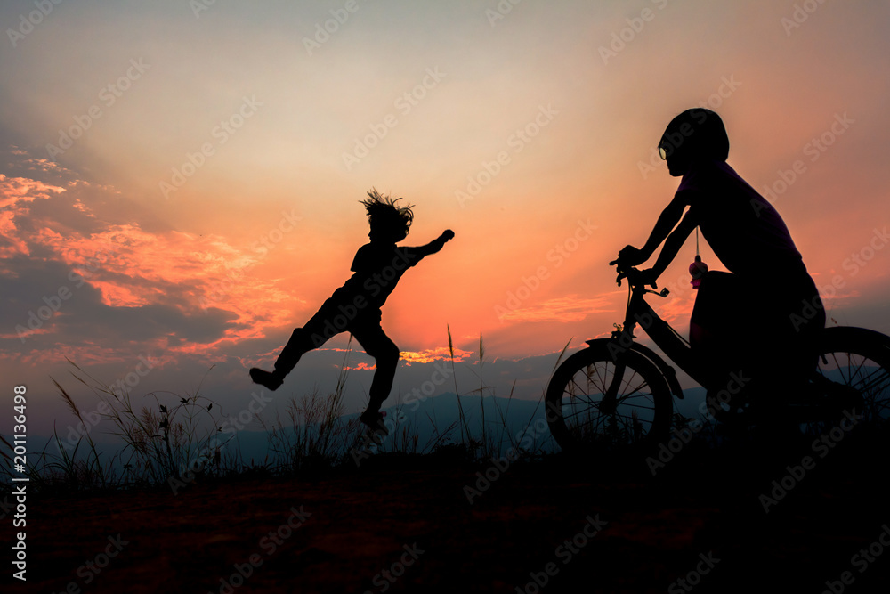 Silhouette of happy children playing jumping on mountain at sunset, summer time Silhouette of happy children playing jumping on mountain at sunset, summer time