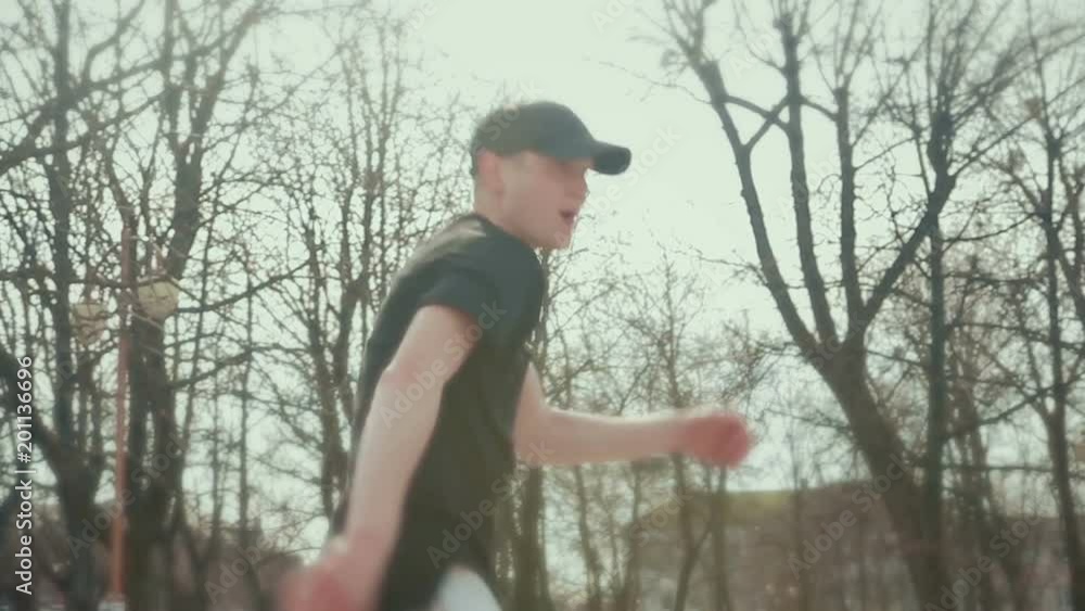 Modern guy in gray pants and a black cap dancing in the city, against the background of passers-by people. Steadicam shot Modern guy in gray pants and a black cap dancing in the city, against the background of passers-by people. Steadicam shot