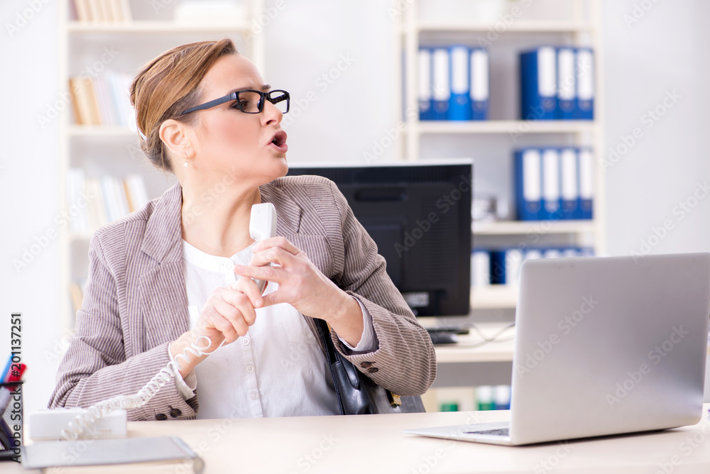 Obraz premium Businesswoman employee talking on the office phone