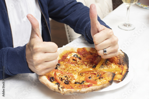 Man giving a baked homemade pizza a thumbs up
