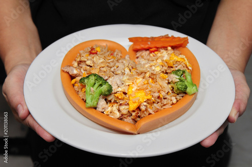 Fototapeta Naklejka Na Ścianę i Meble -  Sausage cheese in heart style wrap fried rice with pork  topped carrot and Broccoli on white plate.