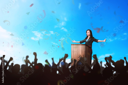 Successful asian business woman giving a speech in front of the people