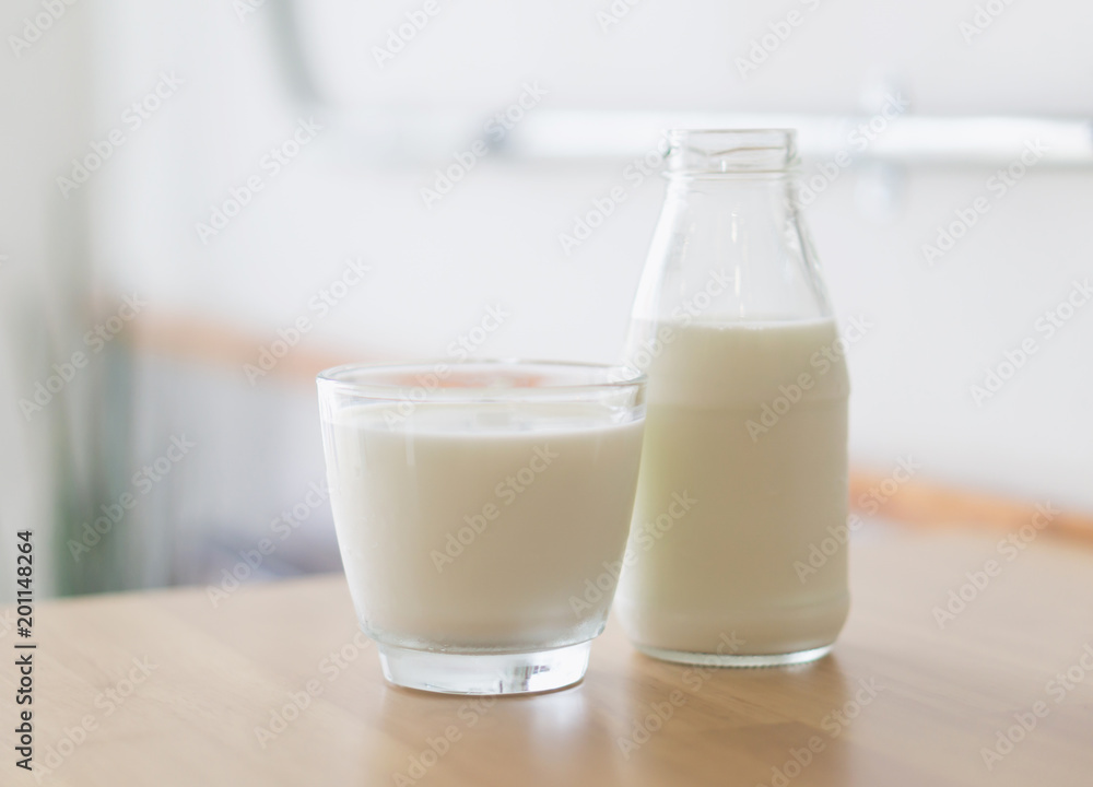 Closeup glass and bottle of millk on wood table background for healthy drink concept, selective and soft focus Closeup glass and bottle of millk on wood table background for healthy drink concept, selective and soft focus