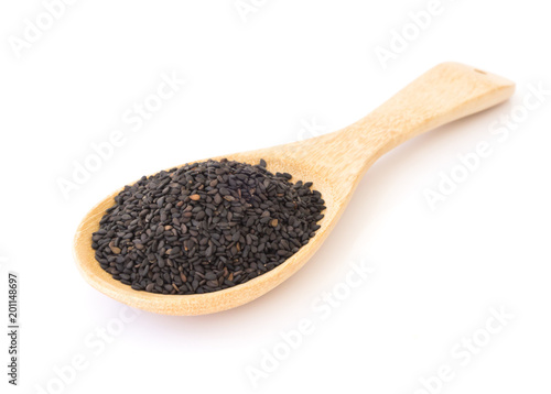 Black sesame on wooden spoon with white background, healthy food concept