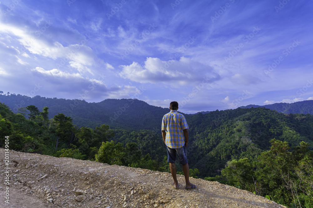 Fototapeta premium a man standing on hilltop look around the valley