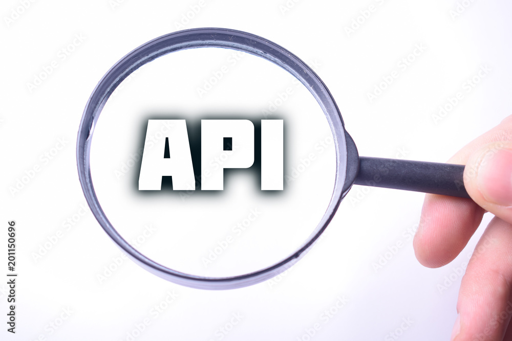 Businessman looking at a magnifying glass word:API Businessman looking at a magnifying glass word:API
