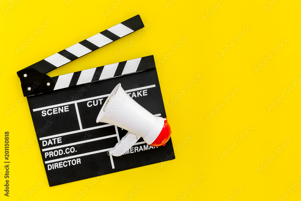 Film director, producer concept. Filming. Electronic megaphone and clapperbord on yellow background top view space for text