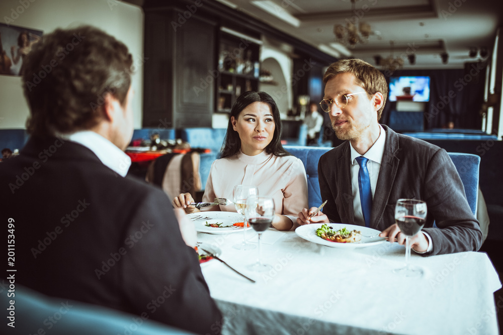 Businesspeople having business lunch in a fine dining restaurant. Discussing new project. Businesspeople having business lunch in a fine dining restaurant. Discussing new project.