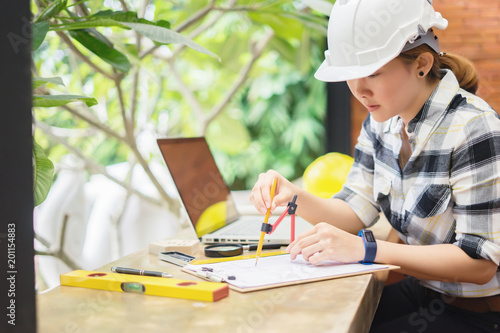 Architect working on blueprint.engineer inspective in workplace - architectural project, blueprints,ruler,calculator,laptop and divider compass. Construction concept. Engineering tools,selective focus photo