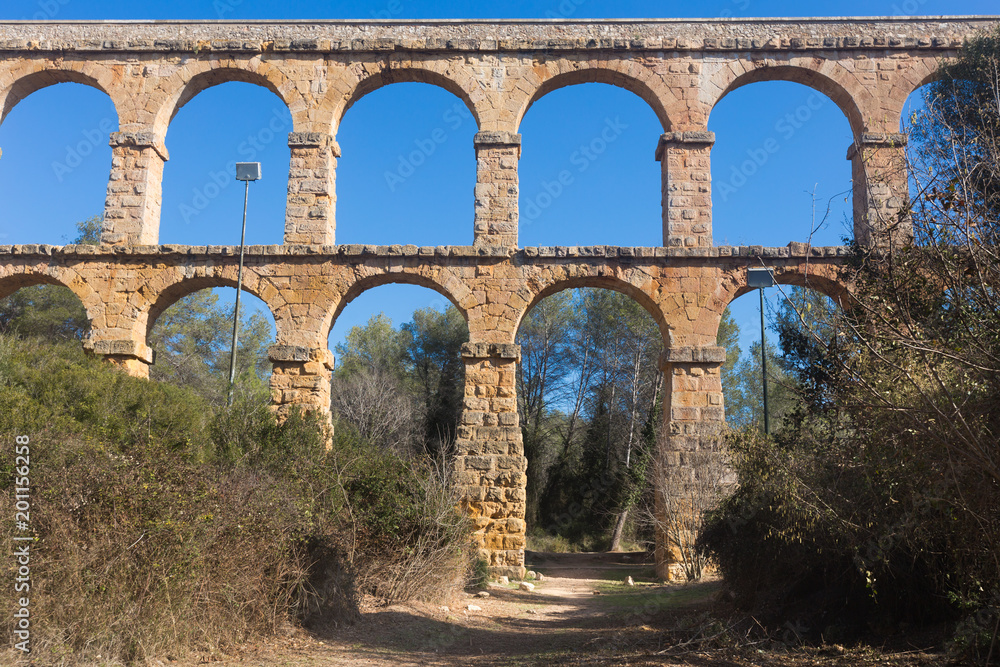 Roman aqueduct in city of Taragona in summer