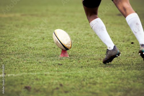 rugby player preparing to kick the oval ball during game