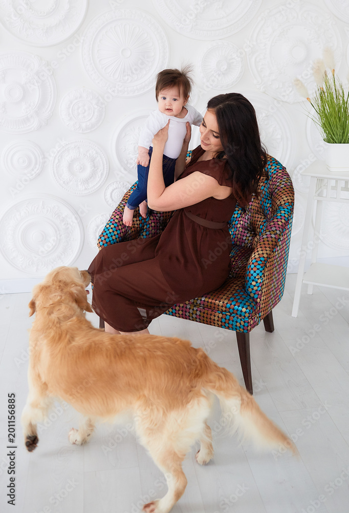 The mother with daughter sitting on the chair near dog