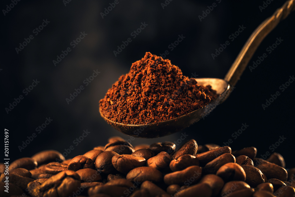 Roasted ground coffee into an old silver spoon and roasting coffee