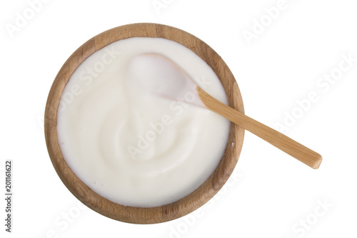 yogurt in a wooden bowl isolated on white background top view