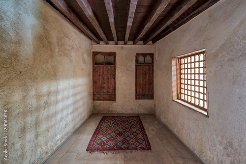 Room at El Sehemy house, a historic old Ottoman era house located in Cairo, built in 1648, with embedded wooden cupboard, wooden window and colorful carpet, Cairo, Egypt photo