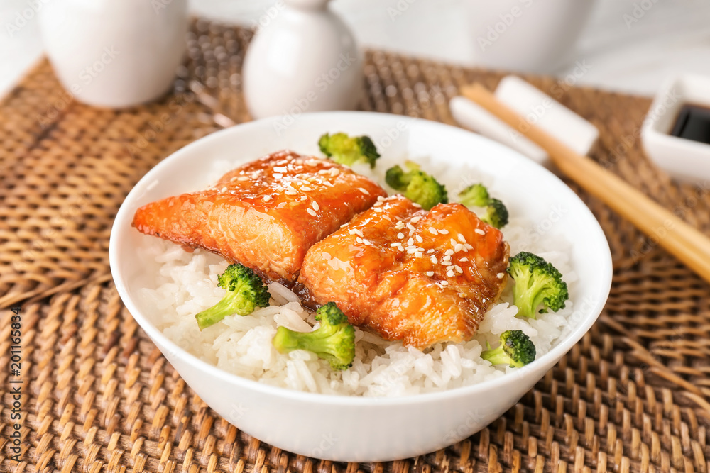 Fish fillet served with rice and broccoli on wicker coaster