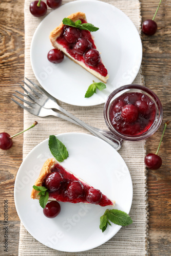 Delicious cheesecake with cherries on plates