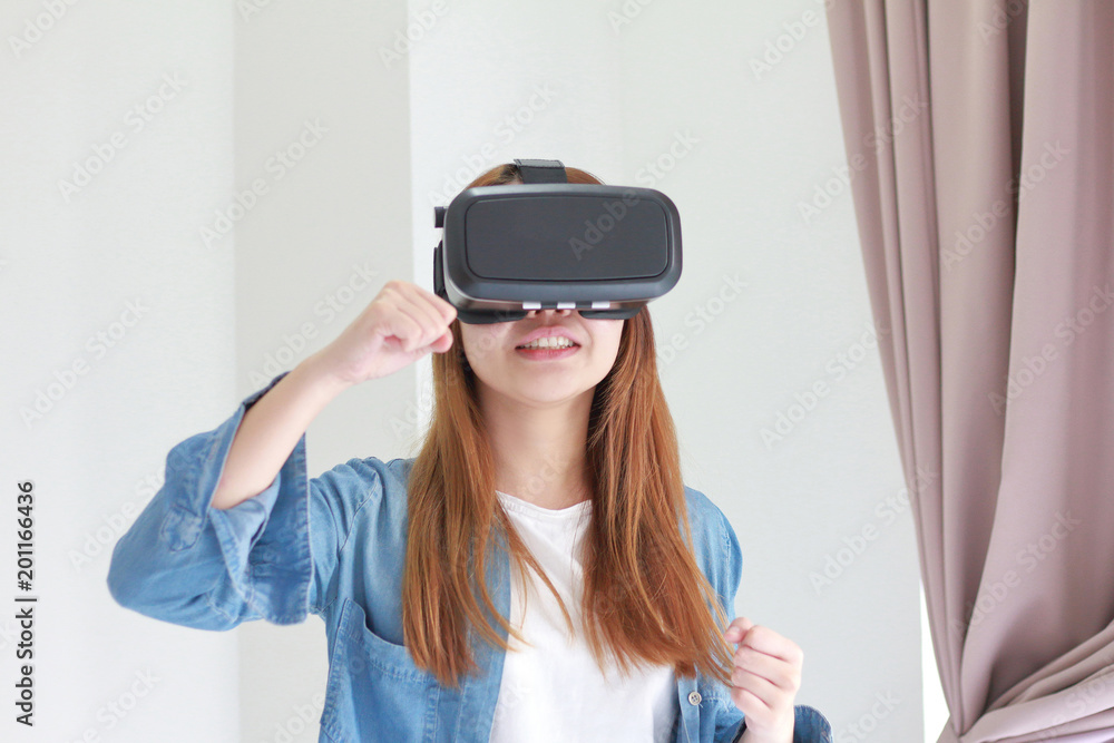 Young woman wearing virtual reality glasses at home. Young woman wearing virtual reality glasses at home.